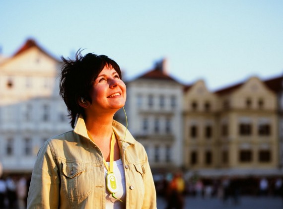 Une touriste heureuse écoutant un guide électronique à Prague
